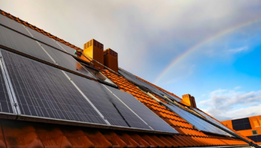 Residential solar panels installed on a sloped rooftop under a clear sky