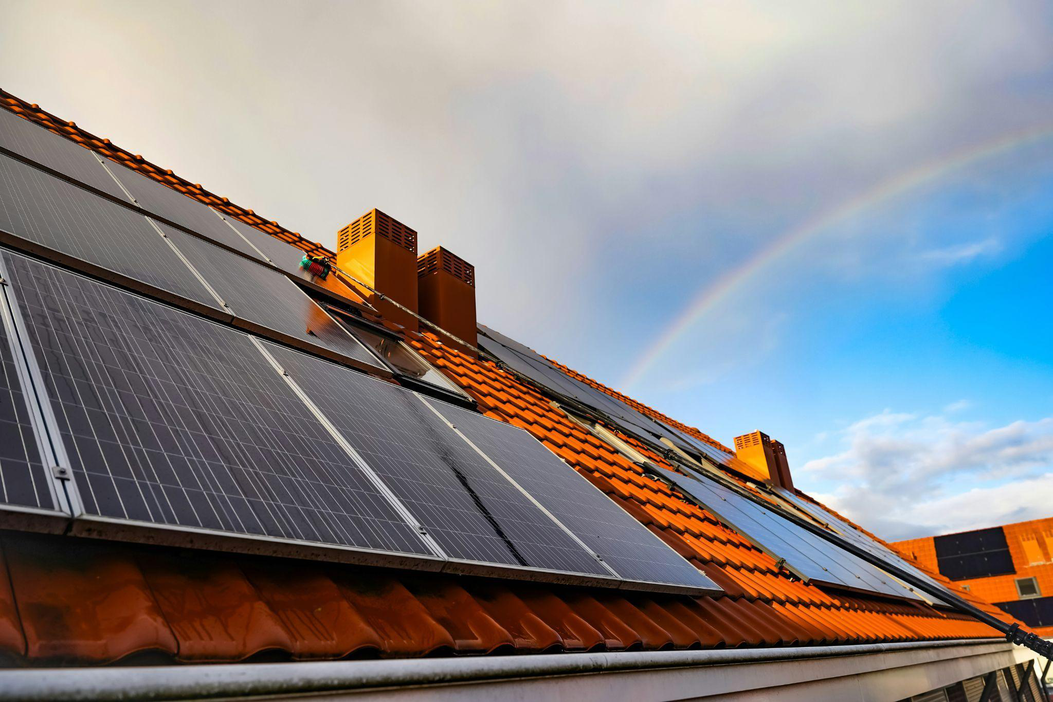 Residential solar panels installed on a sloped rooftop under a clear sky