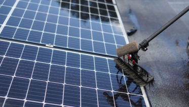Solar panel cleaning in process using a brush to remove dirt and debris from the surface