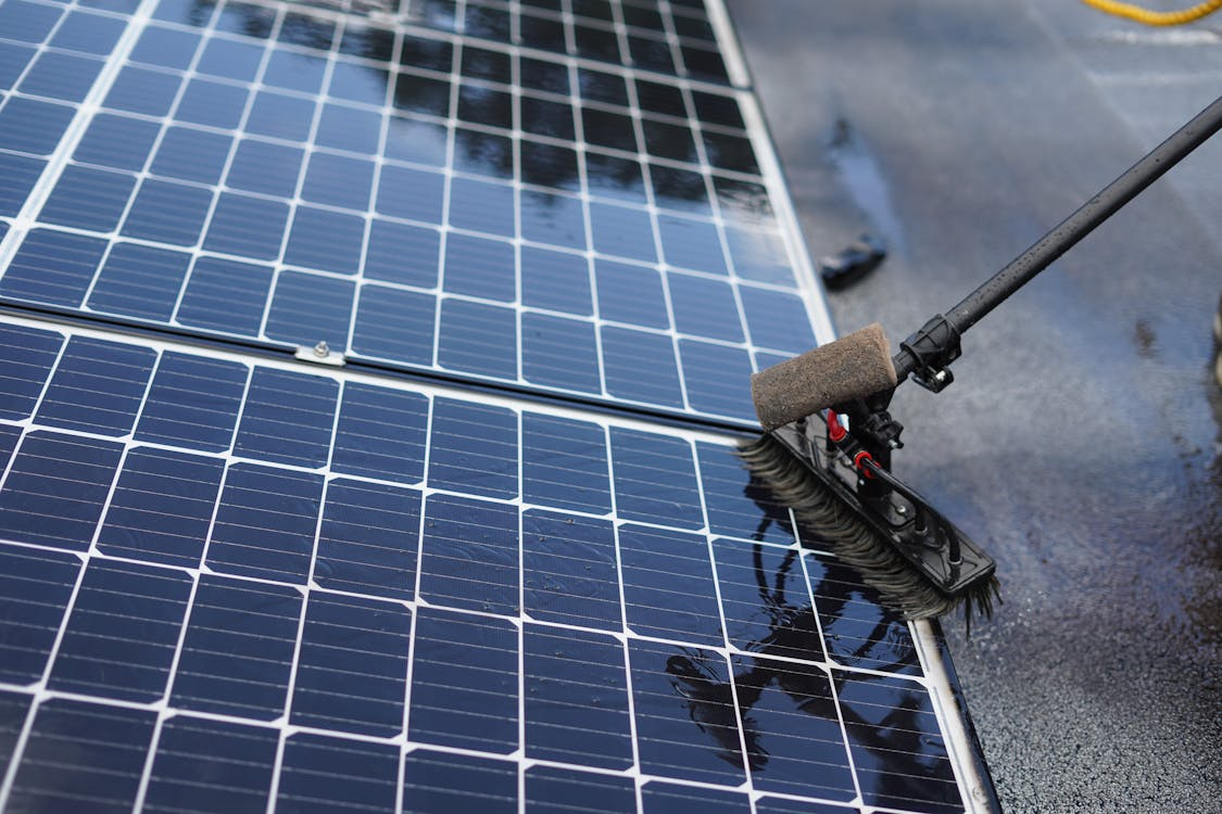 Solar panel cleaning in process using a brush to remove dirt and debris from the surface