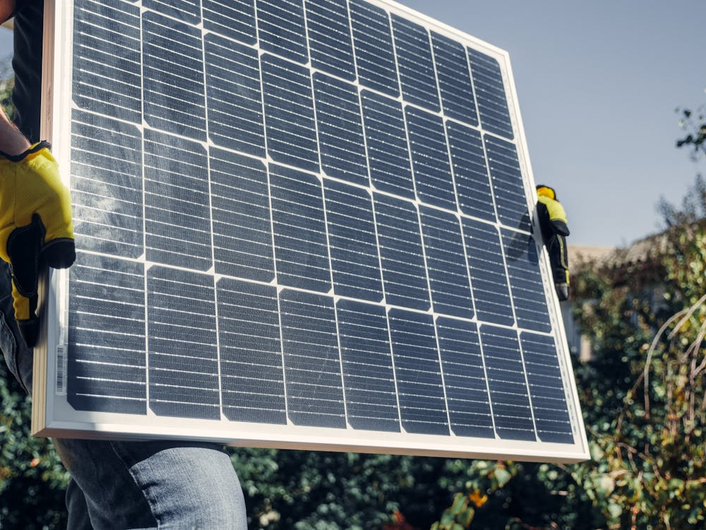 Technician holding a solar panel during a professional inspection and repair service