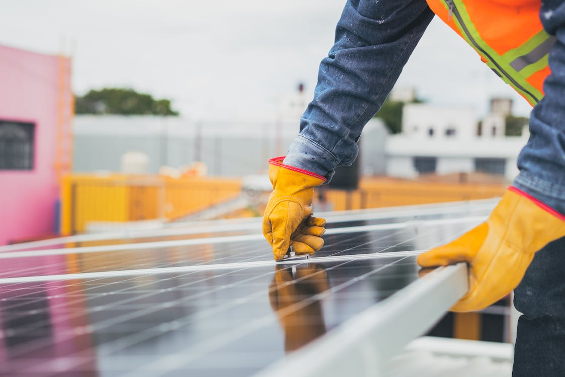 Professional technician installing a solar panel on a residential rooftop solar system
