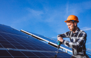 Licensed solar contractor repairing a solar panel on a home rooftop.