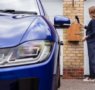 Woman connecting a universal EV charger to her electric vehicle at home.