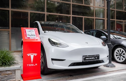 White Tesla parked in a residential driveway