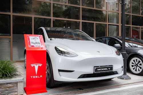 White Tesla parked in a residential driveway