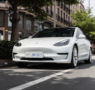 A high-end electric sedan driving along a road.