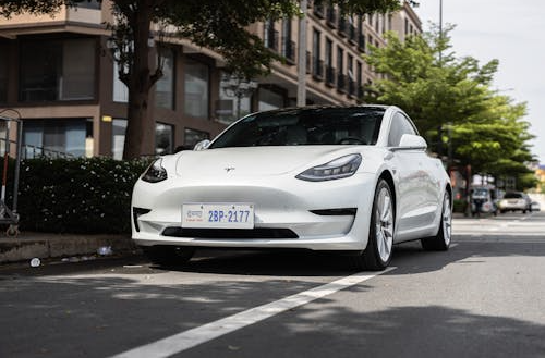 A high-end electric sedan driving along a road.