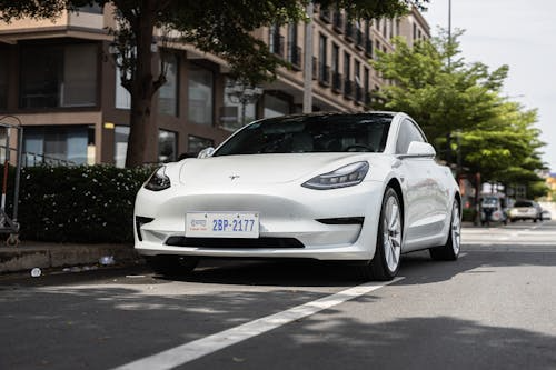 A high-end electric sedan driving along a road.