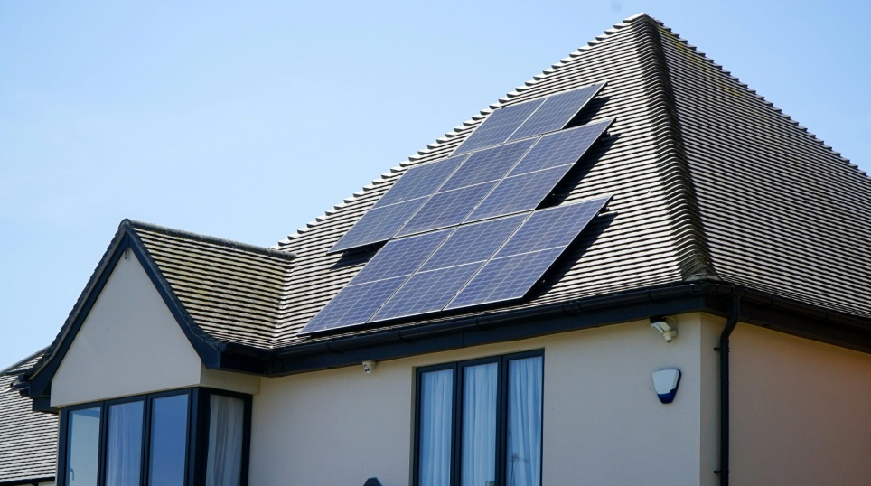A home with a set of solar panels installed across the primary roof section.