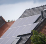 A modern home featuring a full array of solar panels installed on a slanted roof.