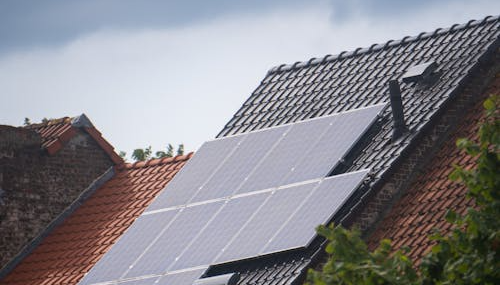 A modern home featuring a full array of solar panels installed on a slanted roof.