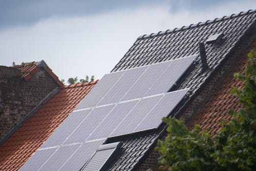 A modern home featuring a full array of solar panels installed on a slanted roof.