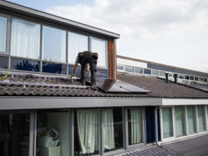 A technician working to dust off a solar array.