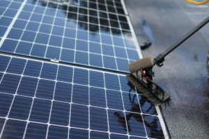 Professional solar panel cleaning using specialised equipment on a rooftop system
