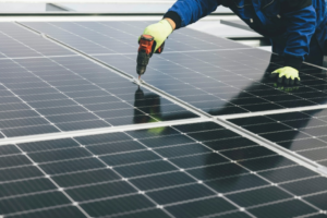 Technician using tools to repair and inspect a solar panel system