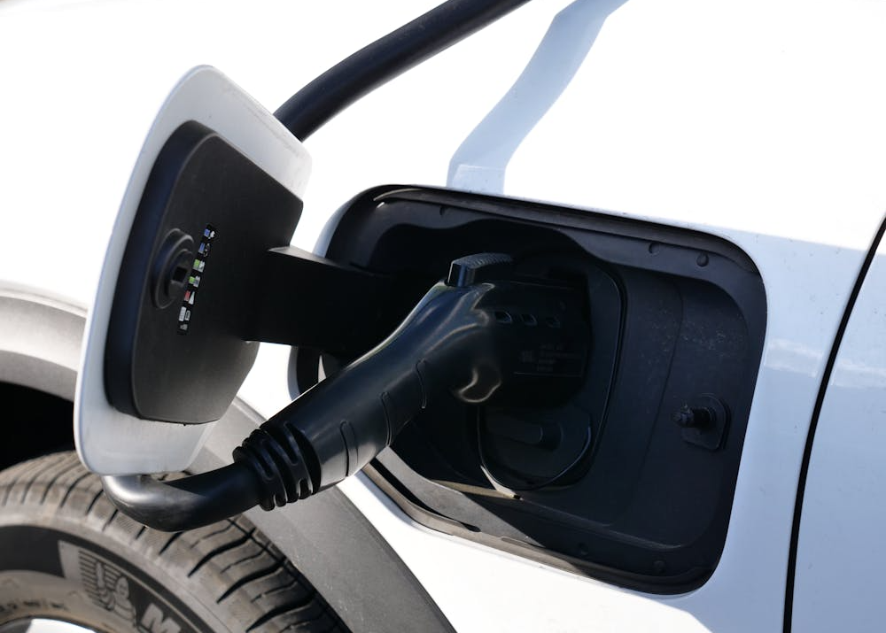 a Tesla Wall Connector mounted in a San Francisco home garage next to a parked electric vehicle