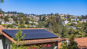 An older residential solar panel array on a Bay Area roof showing weathered panels and mounting hardware