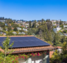 An older residential solar panel array on a Bay Area roof showing weathered panels and mounting hardware