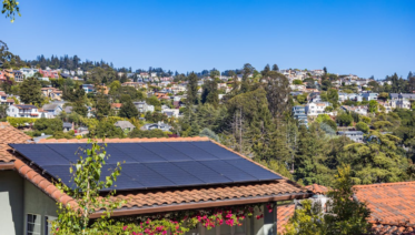 An older residential solar panel array on a Bay Area roof showing weathered panels and mounting hardware