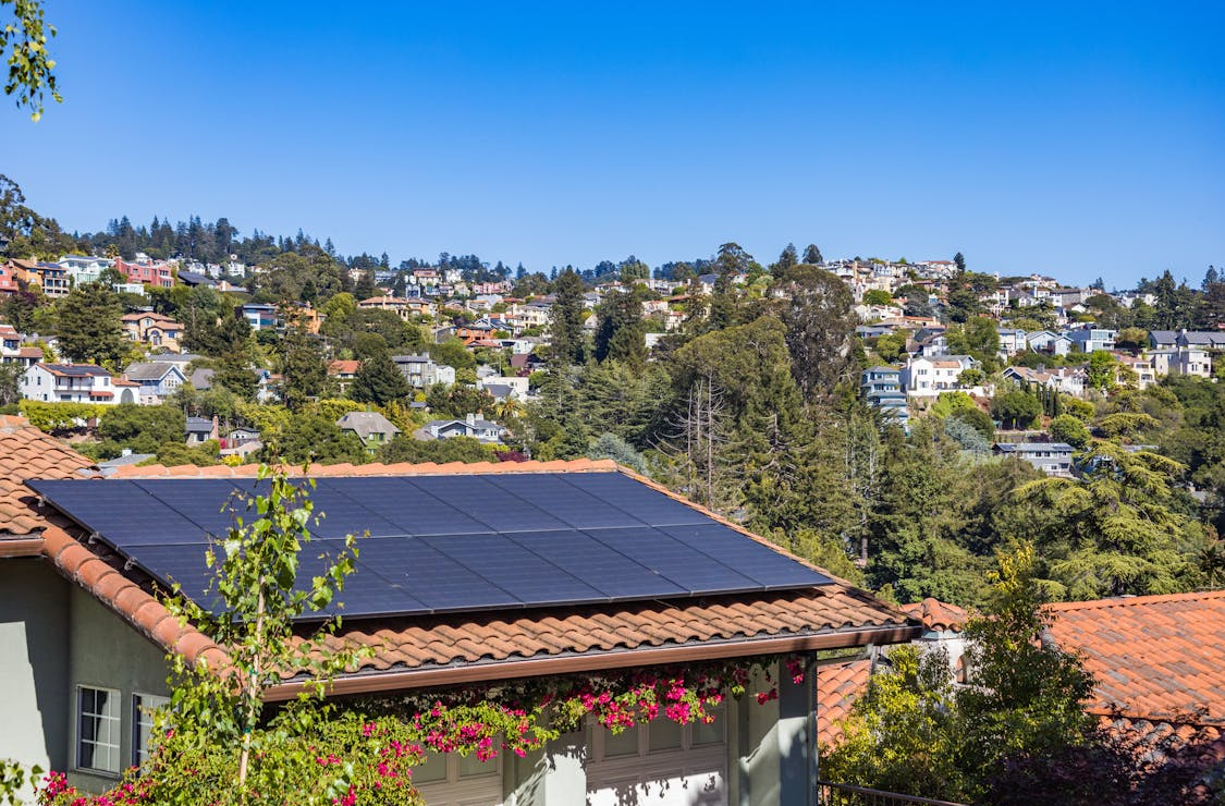 An older residential solar panel array on a Bay Area roof showing weathered panels and mounting hardware