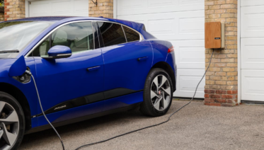 a car plugged into a Level 2 home EV charger in a clean residential garage in the Bay Area