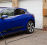 a car plugged into a Level 2 home EV charger in a clean residential garage in the Bay Area