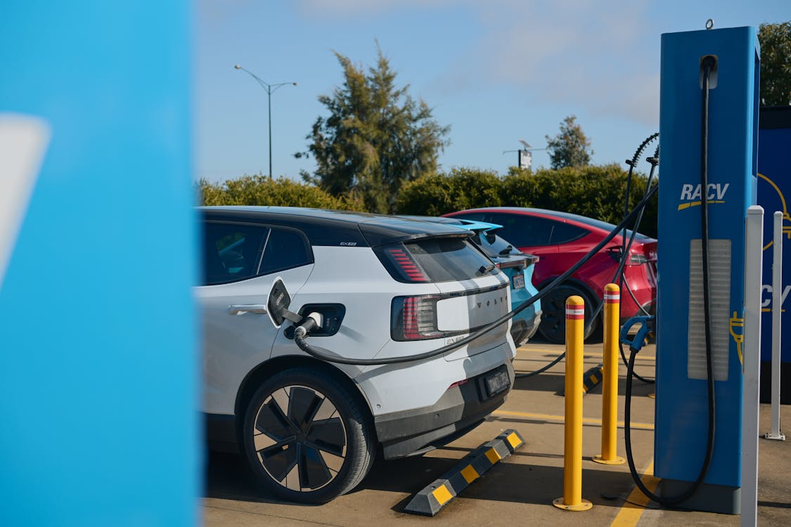 multiple electric vehicles queued at a busy public charging station in San Francisco