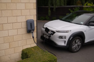 White electric car charging using a wall-mounted EV charger.
