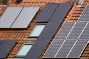 Close-up view of solar panels mounted on a tiled residential roof under clear daylight conditions.