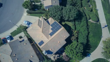 Top-down aerial view of a residential home with solar panels installed on the roof.