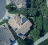 Top-down aerial view of a residential home with solar panels installed on the roof.