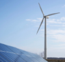 A large wind mills near to solar power plates.