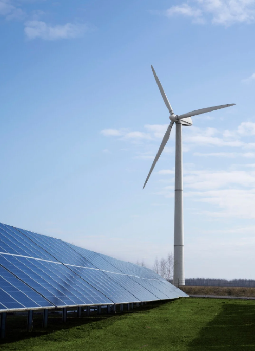 A large wind mills near to solar power plates.